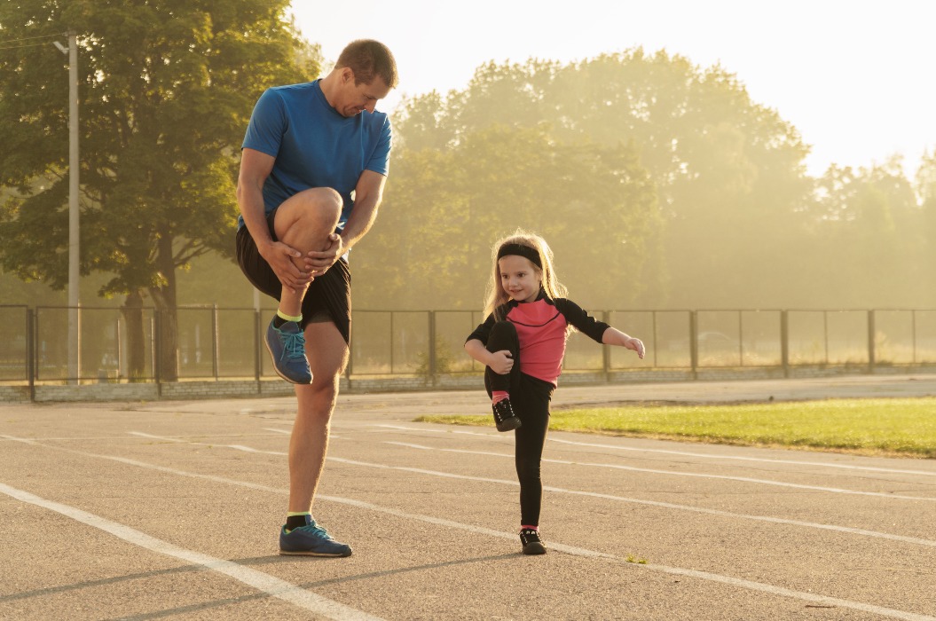 Vater und Tochter betreiben Sport. Vater und Tochter im Stadion.